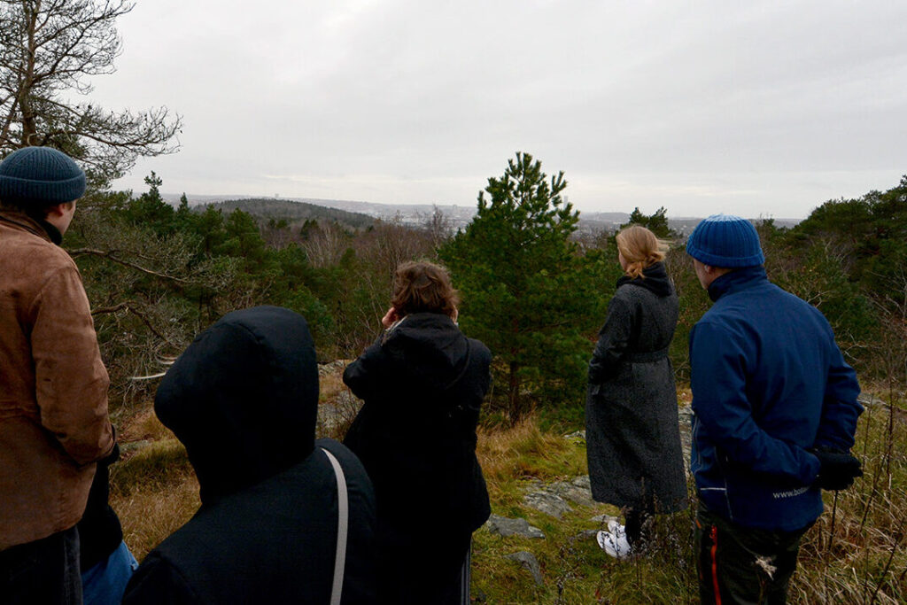 En grupp människor står på ett berg och lyssnar på ett ljudverk.