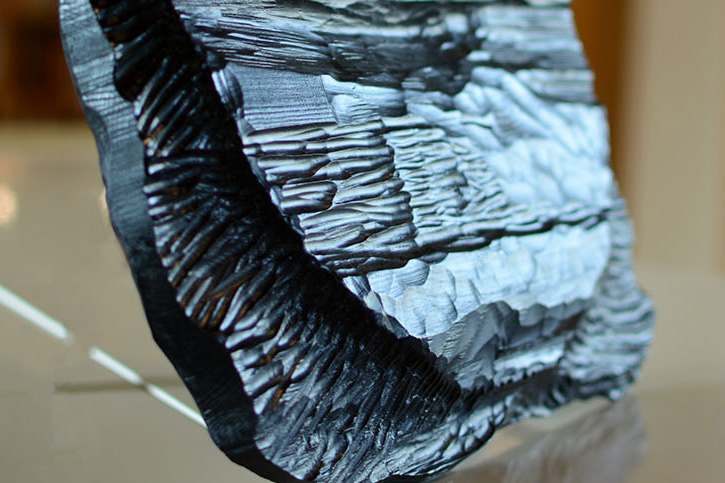 Detaljbild av den svarta reliefen Wærma. Snidad i värmländsk furu.